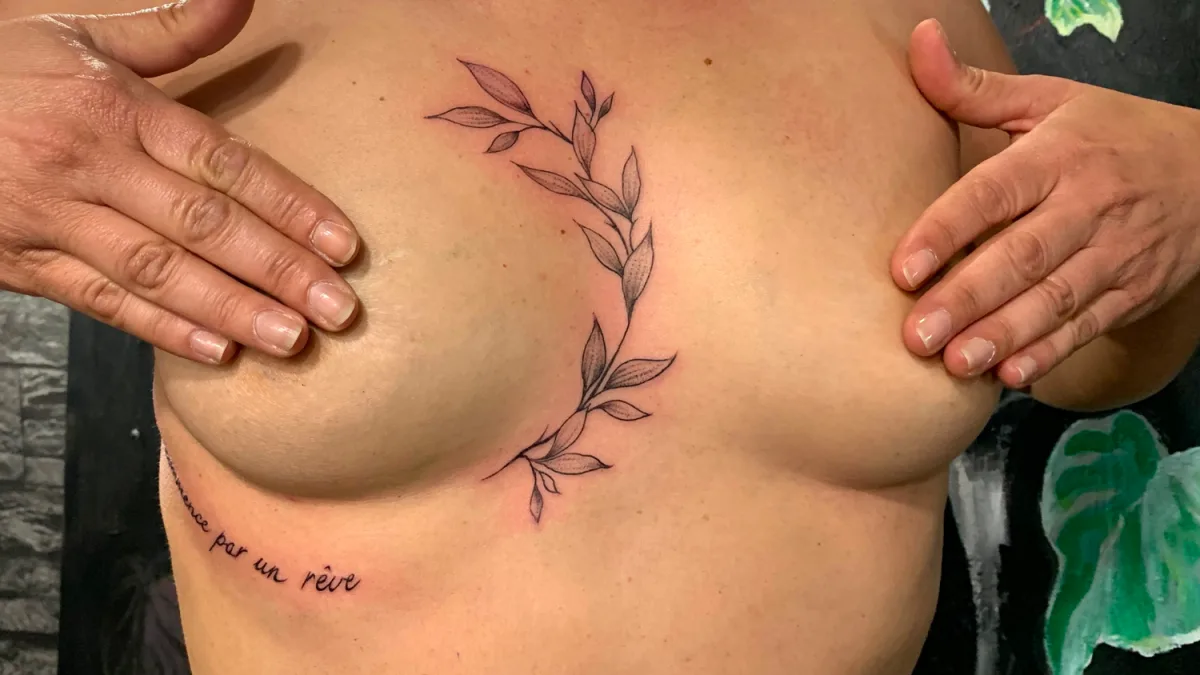 Tatouage poitrine calligraphie et végétal